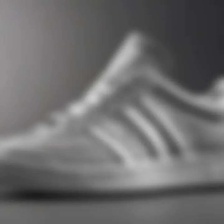 Close-up of the texture and design elements of gray and white Adidas shoes.