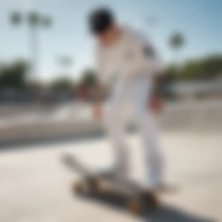 A skateboarder wearing all white Adidas pants in an urban skate park setting.