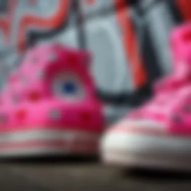 Close-up of pink Converse adorned with heart motifs against a graffiti wall