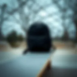 A black backpack resting on a skateboard at a skate park