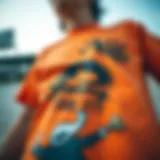 Close-up of an orange graphic tee featuring a bold design related to skateboarding.