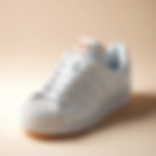 Classic all-white Adidas Superstar shoes on a minimalist background